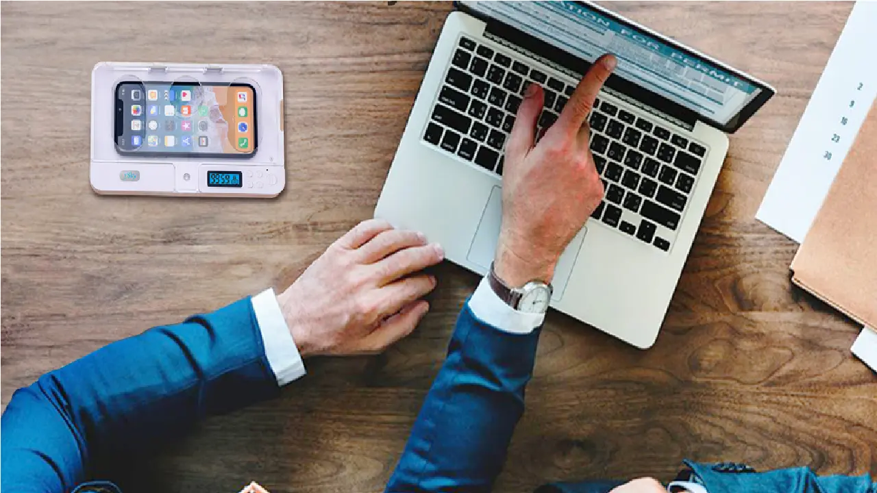 A person placing their smartphone into a timed lock box on a desk to improve focus.