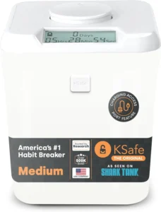 The see-through KSafe Mini lock box with its white lid, containing a phone and snacks.
